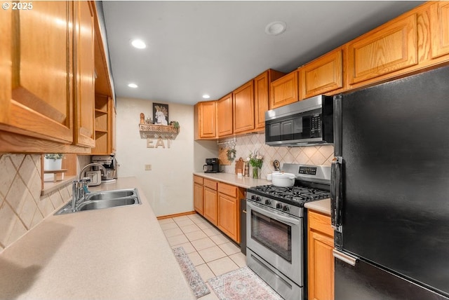 kitchen featuring black appliances, a sink, recessed lighting, light tile patterned flooring, and light countertops