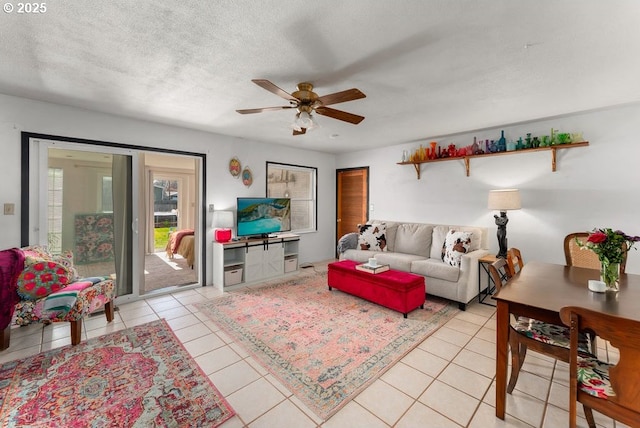 living area with light tile patterned floors, a ceiling fan, and a textured ceiling