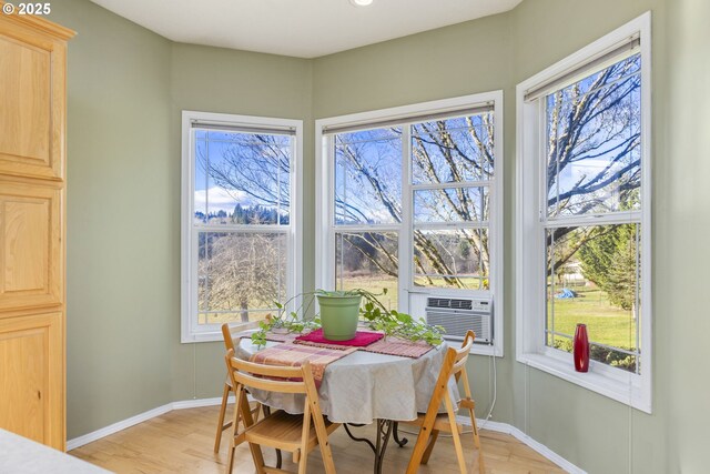 dining space featuring cooling unit and light wood-type flooring