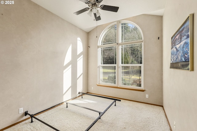 carpeted spare room featuring plenty of natural light and ceiling fan