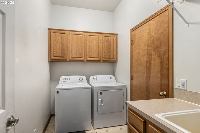 clothes washing area featuring cabinets, independent washer and dryer, and sink