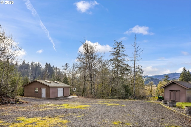 exterior space with a mountain view, a shed, and a garage