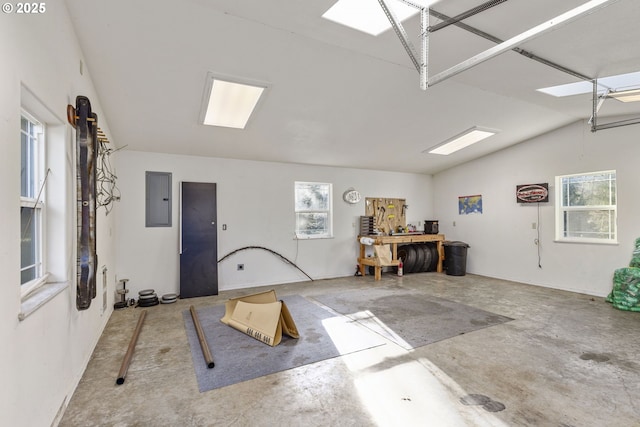 interior space featuring a workshop area, electric panel, a wealth of natural light, and concrete floors