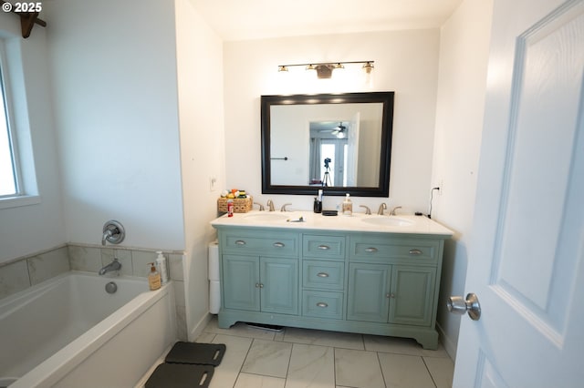 bathroom featuring a sink, baseboards, double vanity, and a garden tub