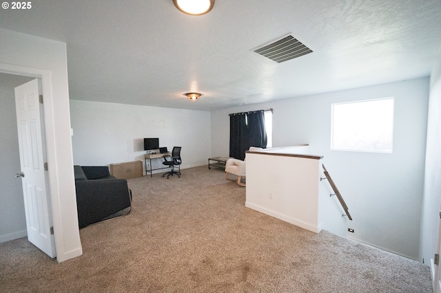 carpeted office space featuring baseboards and visible vents