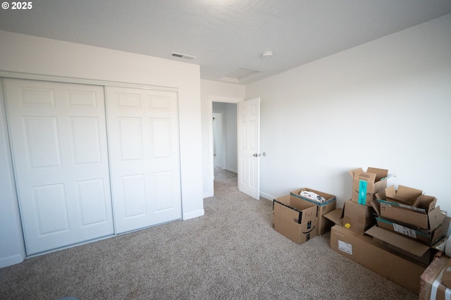 unfurnished bedroom with visible vents, a closet, baseboards, and carpet floors