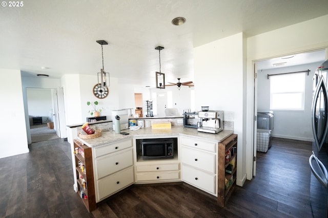 kitchen with a peninsula, freestanding refrigerator, dark wood finished floors, and built in microwave
