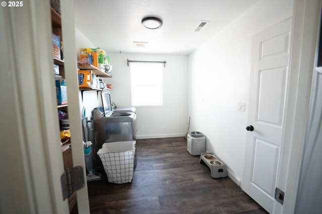clothes washing area with baseboards, washing machine and dryer, dark wood-style floors, visible vents, and laundry area