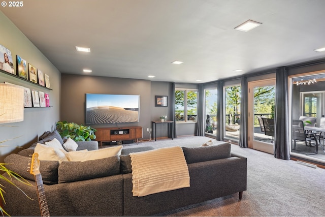 carpeted living room with recessed lighting, a healthy amount of sunlight, and visible vents