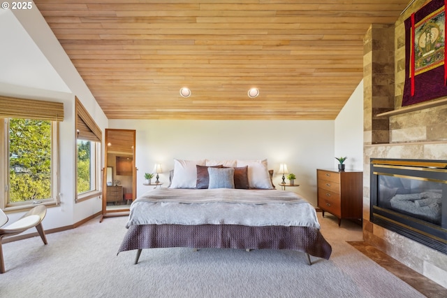 bedroom with lofted ceiling, baseboards, light colored carpet, wood ceiling, and a tile fireplace