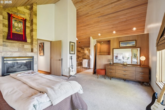 bedroom with wood ceiling, a tile fireplace, baseboards, high vaulted ceiling, and carpet