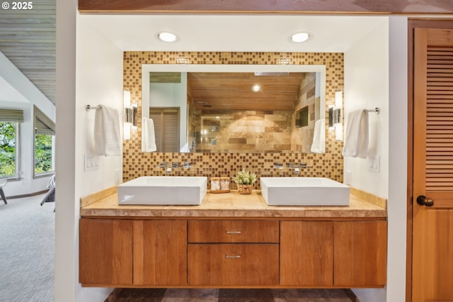 full bathroom featuring a sink, double vanity, recessed lighting, and tiled shower
