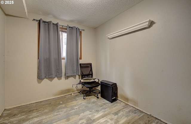 interior space featuring a textured ceiling and wood finished floors