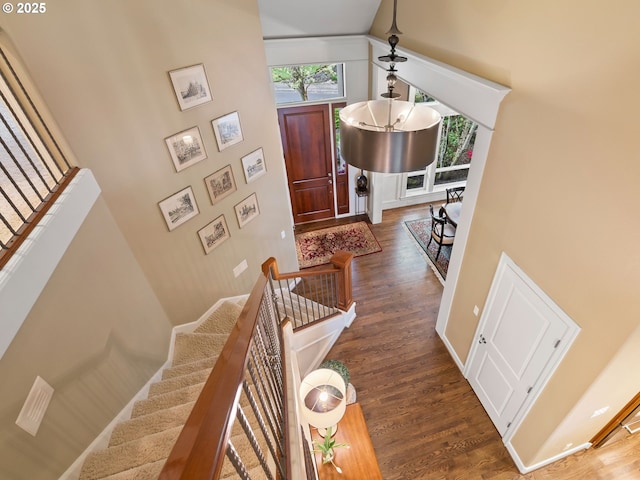 foyer entrance featuring wood finished floors, a towering ceiling, and stairway
