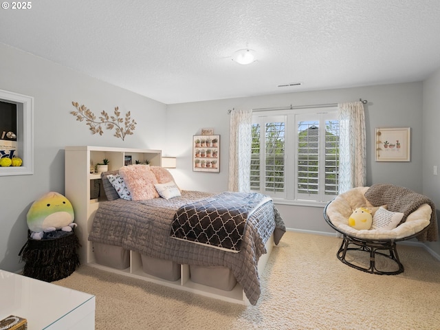 bedroom featuring a textured ceiling, carpet flooring, and visible vents