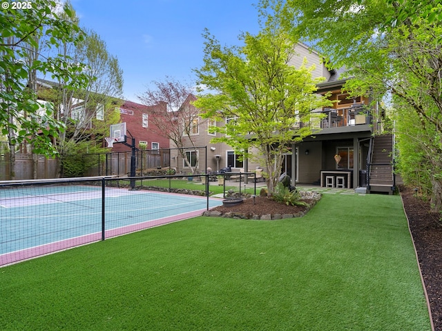 view of basketball court with fence, a yard, and a tennis court