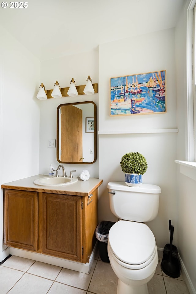 bathroom with toilet, vanity, and tile patterned floors