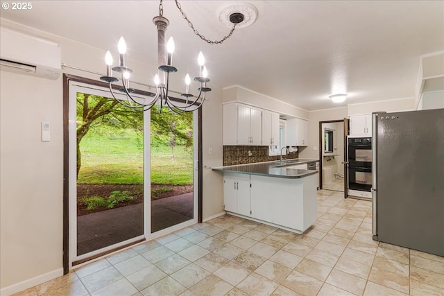 5713 Lewis River Rd, Ariel, WA 98603 - kitchen with freestanding refrigerator, a wall mounted air conditioner, a peninsula, dark countertops, and white cabinets