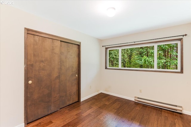 5713 Lewis River Rd, Ariel, WA 98603 - unfurnished bedroom with a baseboard radiator, wood finished floors, baseboards, and a closet