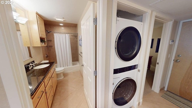 washroom with light tile patterned floors, stacked washing maching and dryer, laundry area, and a sink