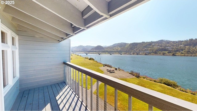 balcony featuring a water and mountain view
