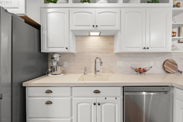 kitchen with a sink, stainless steel appliances, tasteful backsplash, open shelves, and white cabinetry