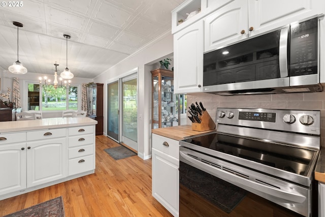 kitchen featuring white cabinetry, stainless steel appliances, backsplash, and light wood-type flooring