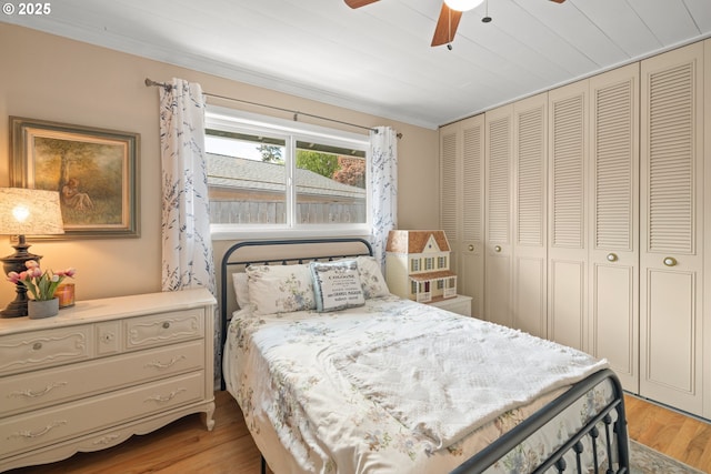 bedroom with ornamental molding, a closet, light wood-style flooring, and ceiling fan