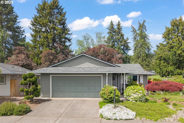 single story home featuring concrete driveway, roof with shingles, and an attached garage