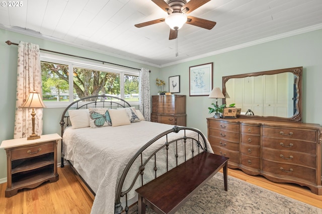 bedroom with crown molding, a ceiling fan, and wood finished floors