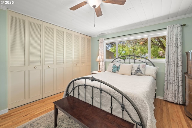 bedroom with ceiling fan, ornamental molding, a closet, and light wood-style floors