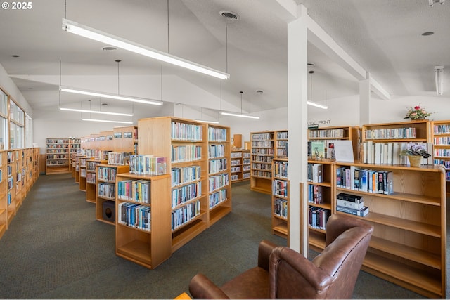 sitting room with bookshelves, carpet floors, high vaulted ceiling, and visible vents
