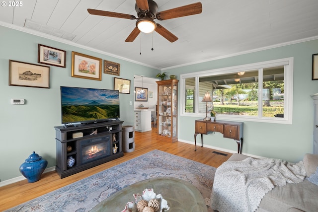 living area with wood finished floors and ornamental molding