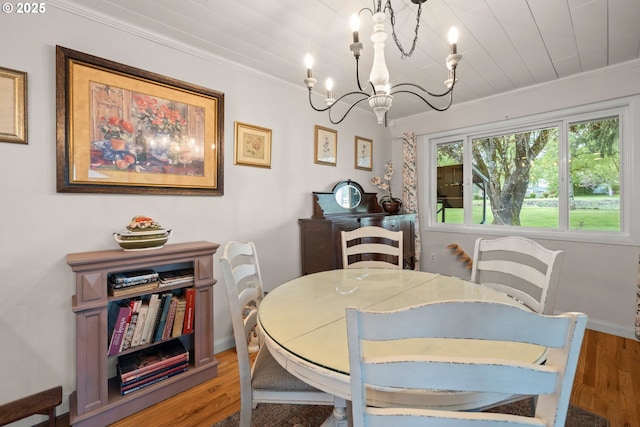 dining area featuring baseboards, crown molding, an inviting chandelier, and light wood-type flooring