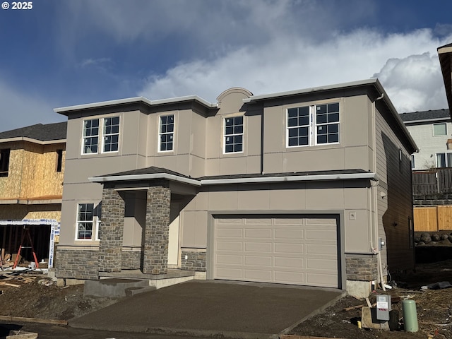 view of front of property with concrete driveway, an attached garage, stone siding, and stucco siding