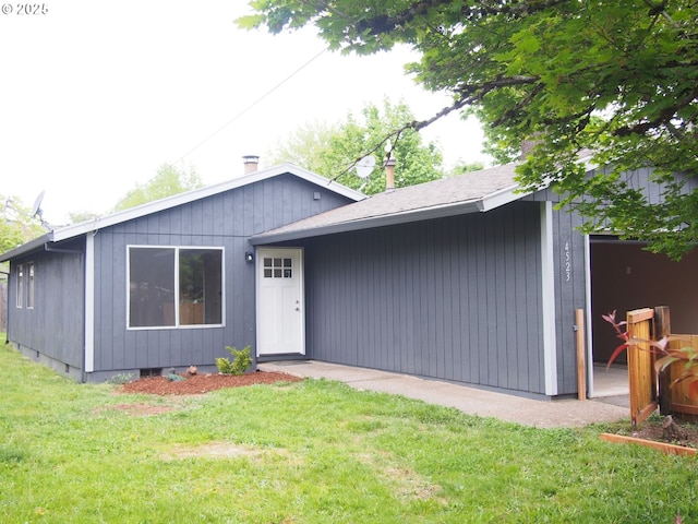 ranch-style house featuring roof with shingles and a front yard