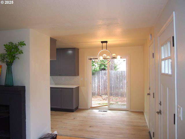 unfurnished dining area featuring plenty of natural light, light wood finished floors, visible vents, and a chandelier