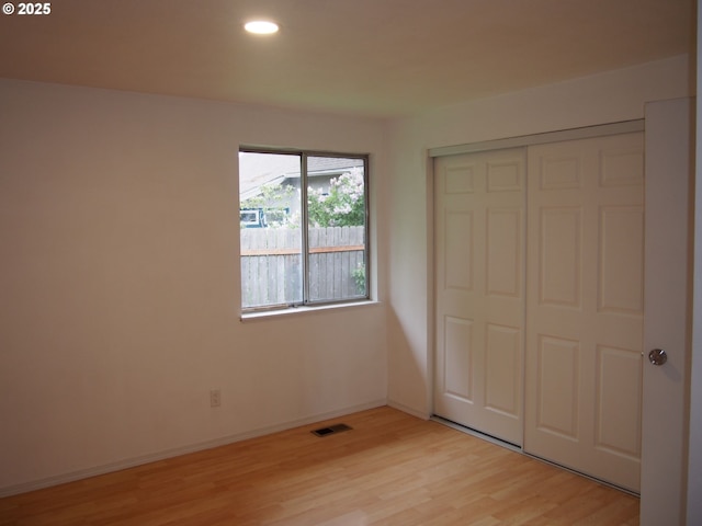 unfurnished bedroom with light wood finished floors, recessed lighting, baseboards, visible vents, and a closet