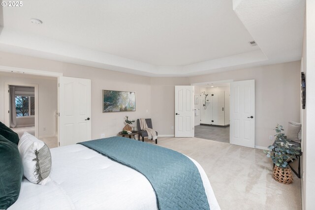 bedroom featuring a raised ceiling, light colored carpet, and baseboards