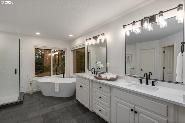 bathroom with recessed lighting, a shower stall, a freestanding bath, double vanity, and tile patterned floors