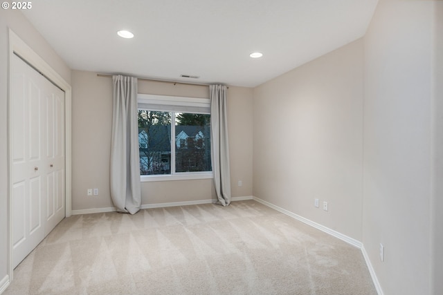 unfurnished bedroom featuring carpet floors, baseboards, recessed lighting, and a closet