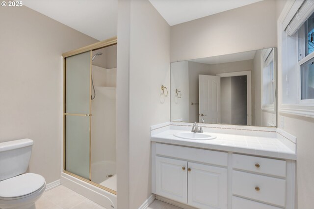 full bath featuring toilet, a stall shower, vanity, tile patterned floors, and baseboards
