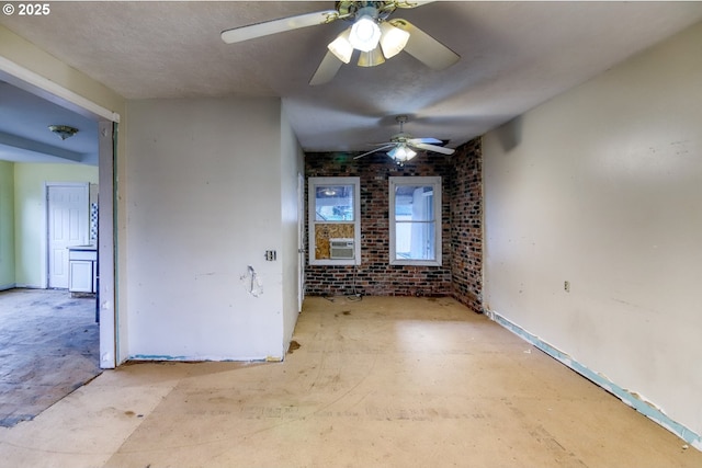 spare room featuring cooling unit and brick wall