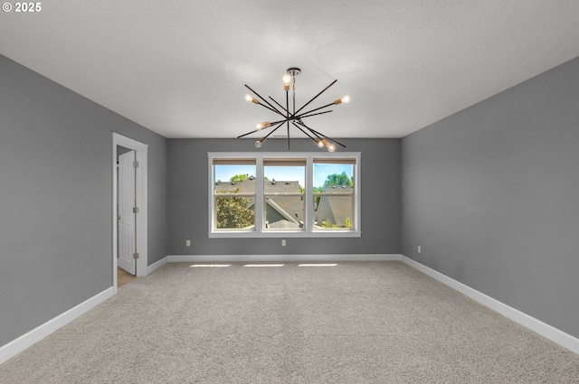 unfurnished room with a chandelier, light carpet, and baseboards