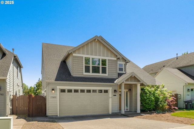 craftsman-style house featuring board and batten siding, driveway, fence, an attached garage, and a shingled roof