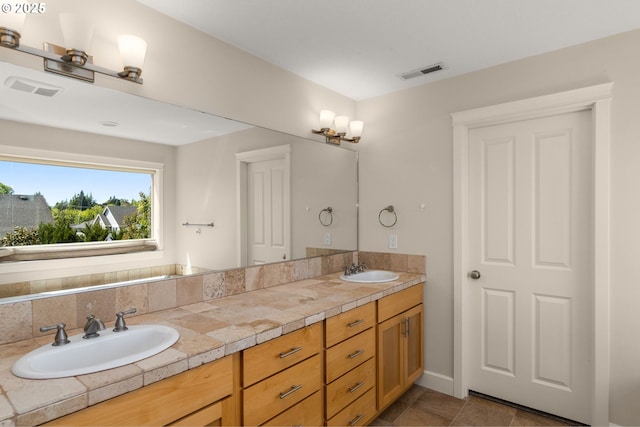 full bathroom featuring double vanity, visible vents, and a sink