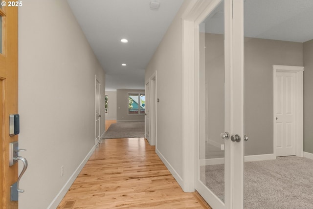 corridor featuring visible vents, light wood-style flooring, baseboards, and recessed lighting