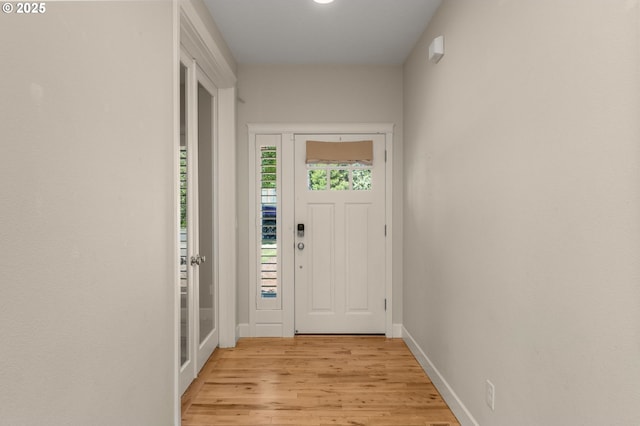 doorway to outside featuring light wood-style flooring and baseboards
