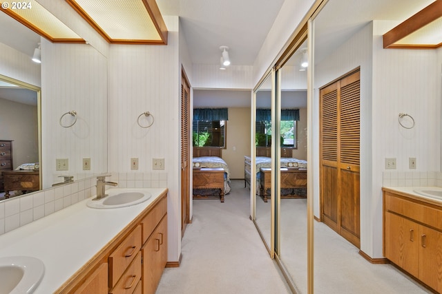 bathroom featuring ensuite bathroom, double vanity, and a sink