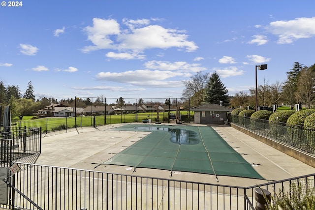 community pool with a patio area and fence